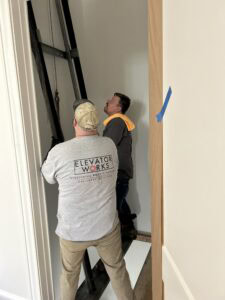 Image of Elevator Works crew viewing interior residential elevator shaft.